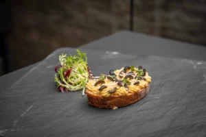 Belegtes Brötchen mit Hummus und Oliven