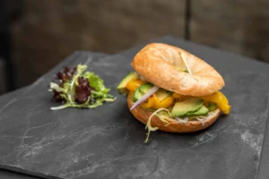 Veganer Bagel – Hummus, gegrillte Paprika, Avocado, Salat