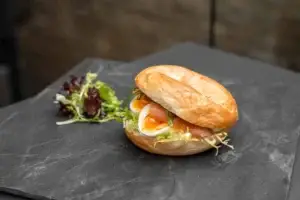 Bagel mit Räucherlachs, Ei und aufgeschlagenem Frischkäse