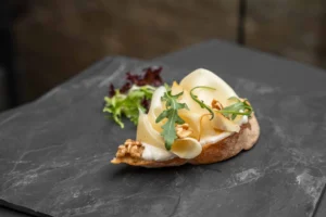 Belegtes Brötchen mit Frischkäseaufstrich und Käsescheiben