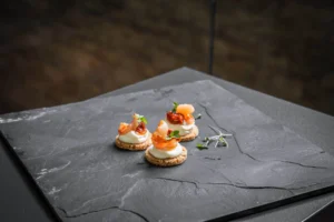 Frischkäse, getrocknete Tomaten und Garnele auf hellem Toast
