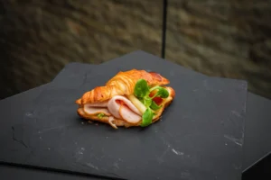 Croissant mit Schinken, Käse und Gurke